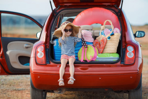 Auto mit offenen Kofferraum. Gepackt für den Urlaub mit Kind im Kofferraum sitzend.