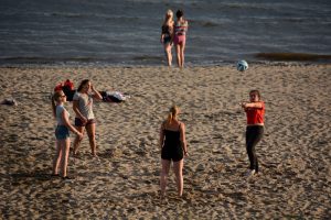 Vollyeballspielende Erwachsene am Strand