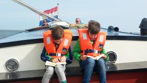 Zwei Jungs lesen im Hecks eines Segelschiffs