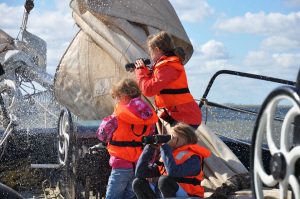 Kinder mit Fernglas im Bug eines Segelschiffs