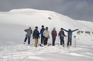 Skigruppe vor einem verschneiten Hügel