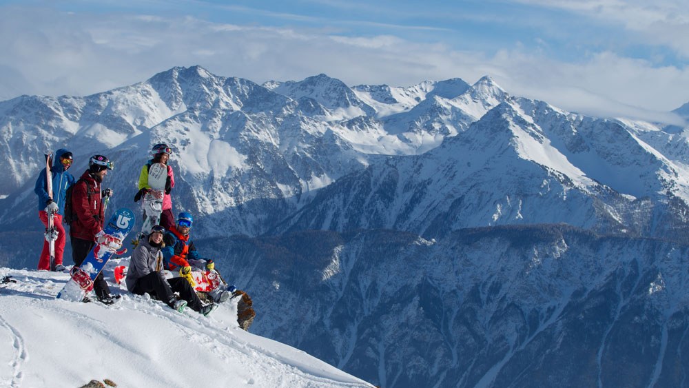 Snowboarder sitzen vor den Bergen