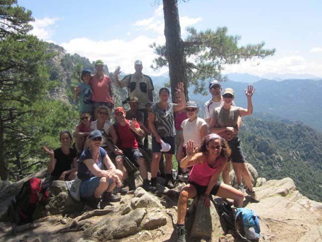 Wandergruppe macht Pause an einem Aussichtspunkt in den Bergen von Korsika