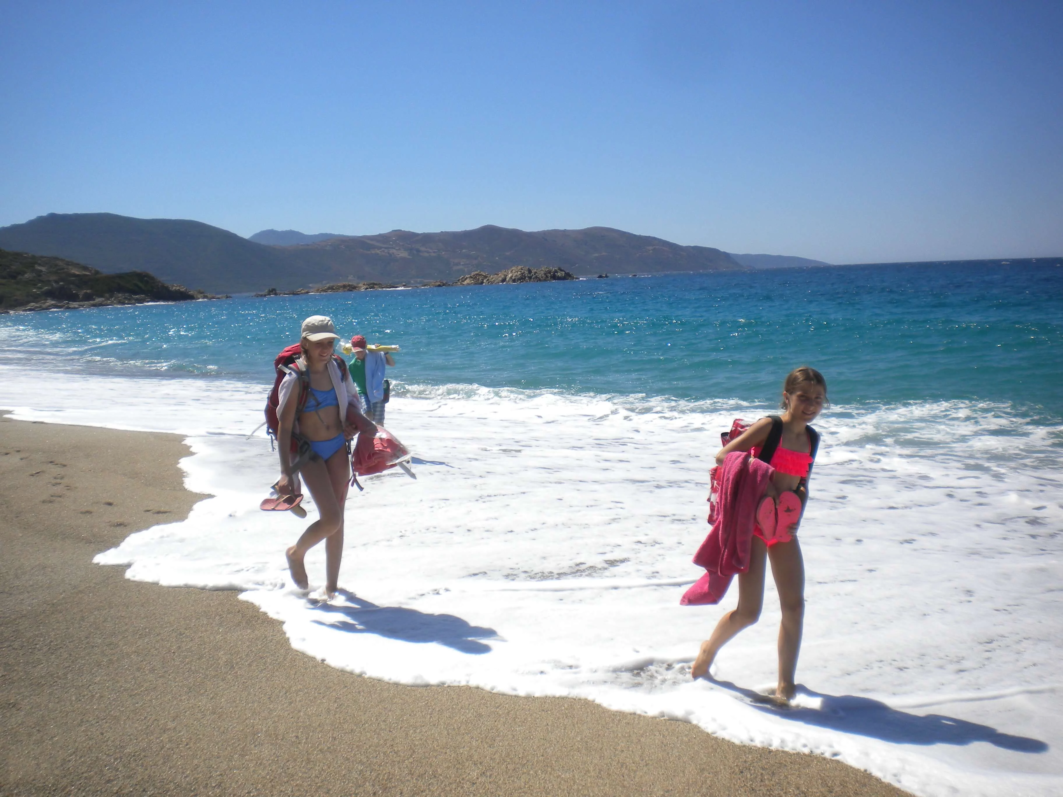 Jugendliche auf dem Weg zum Strand lassen sich von den Wellen die Füße nass machen