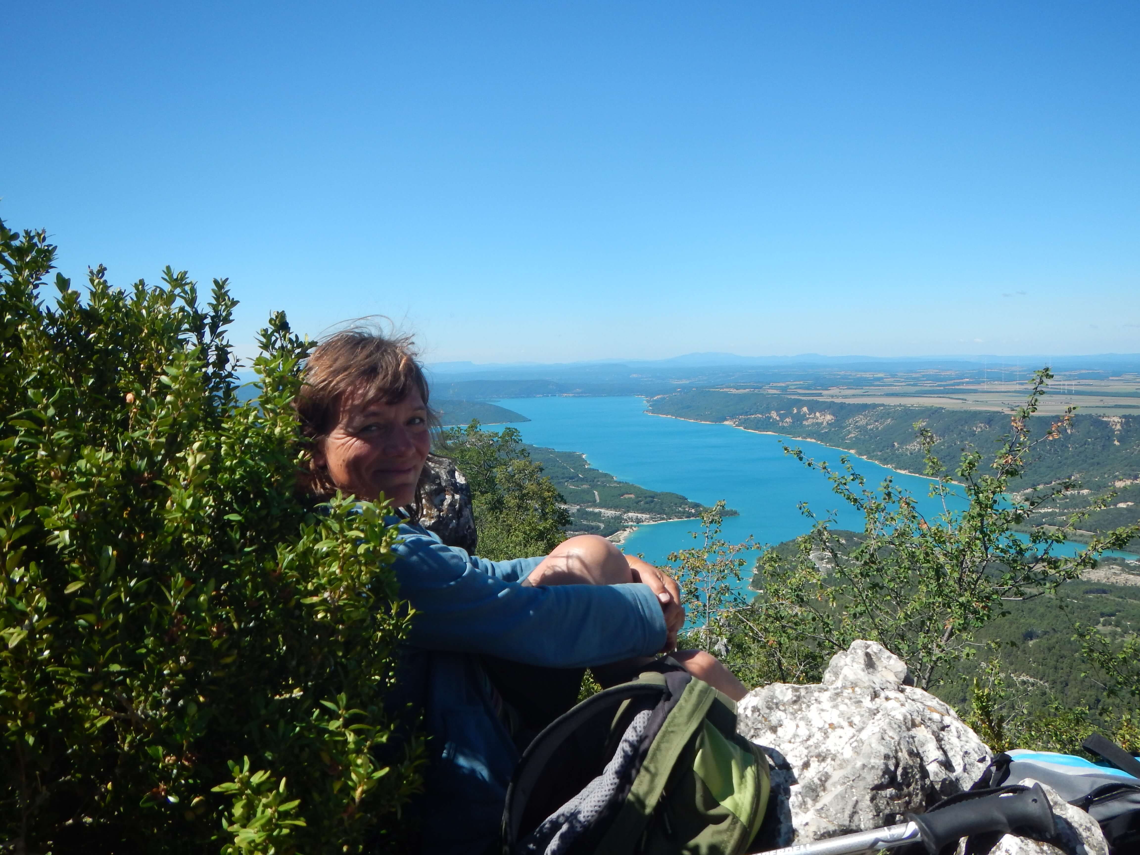 Wanderin macht Pause an einem Aussichtspunkt mit Blick auf den Lac de Ste. Croix