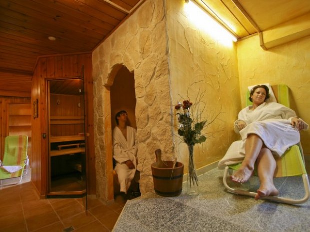 In einer Sauna, zwei Personen im Bademantel.