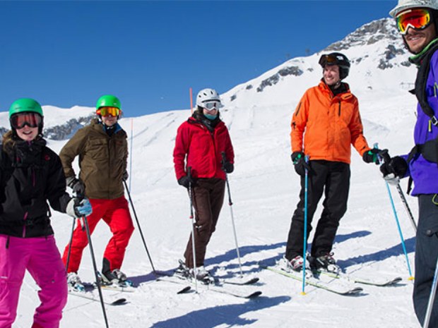 Erwachsenenskikurs pausiert auf der sonnigen Piste in Crnas Montana in der Schweiz