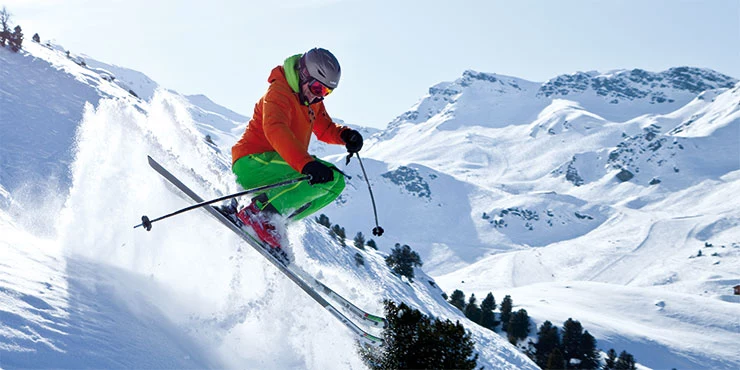 Skifahrer springt in Tiefschnee im Skiurlaub in Le Bettaix in Frankreich
