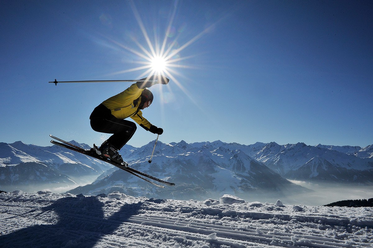Skifahrer springt auf der Piste in Kitzbühel im Sonnenschein