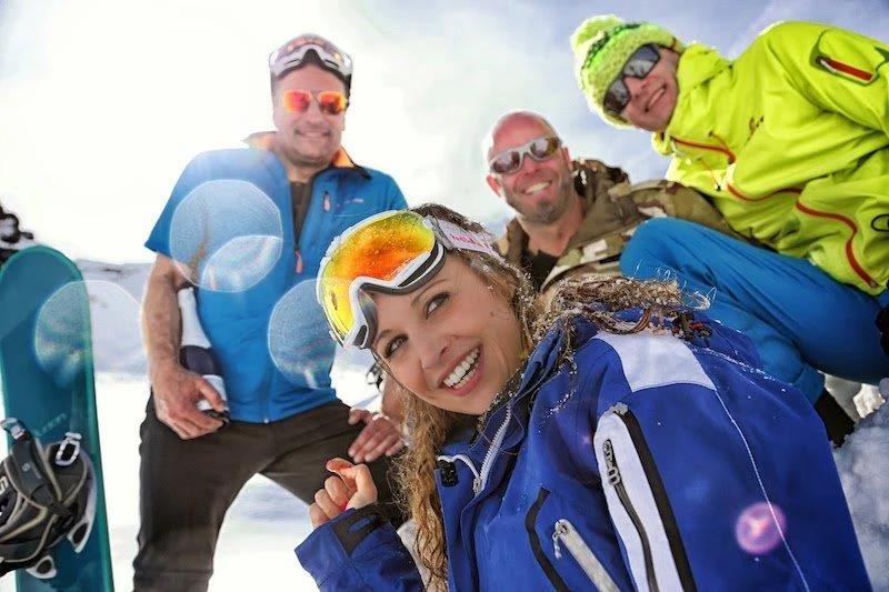 4 Skifahrer, eine Frau und drei Männer, draußen auf dem Schnee