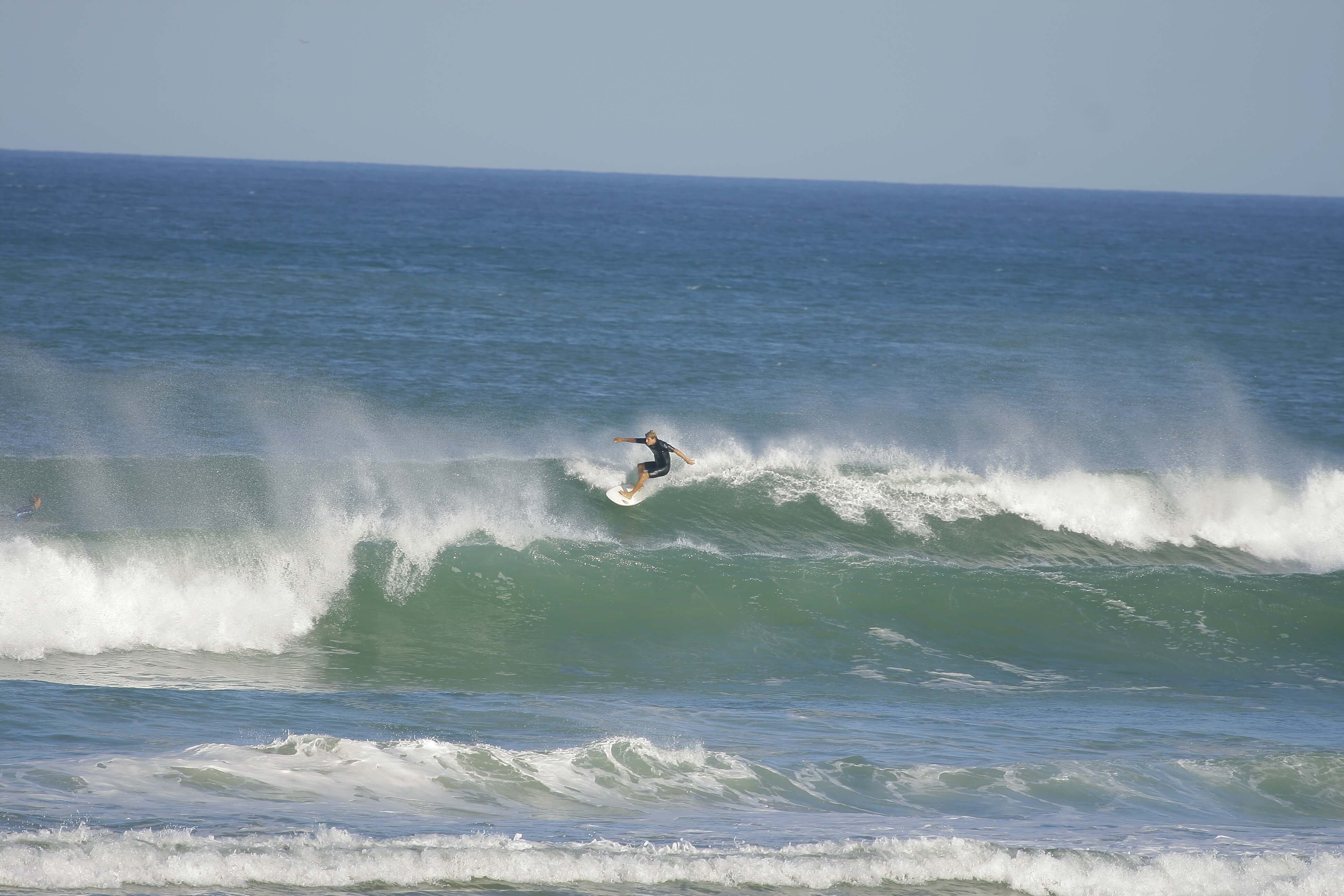 Einzelner Surfer in großen Wellen des Atlantiks im Surfcamp Carcans Plage