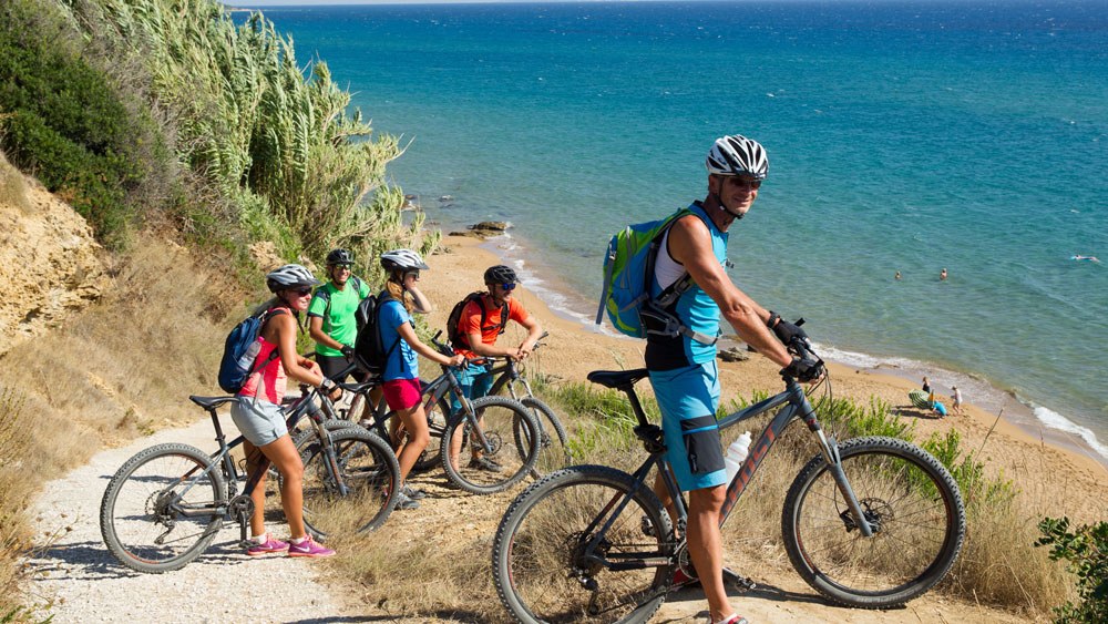 Mountainbiker machen Pause am Strand von Korfu.