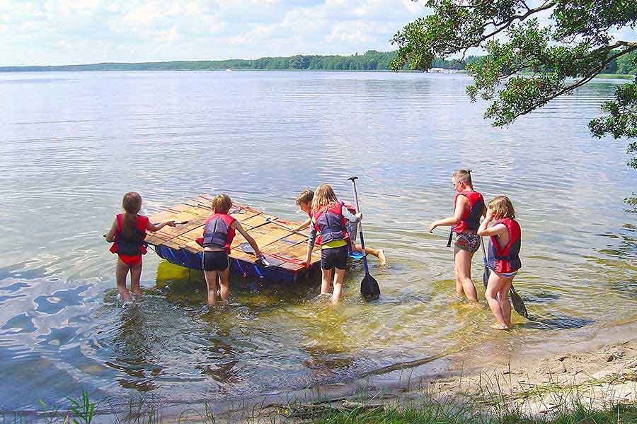 Kinder paddeln auf eigenem Floß