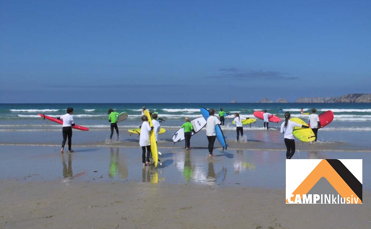 Kinder gehen während eines Surfkurs in die Wellen in der Bretagne