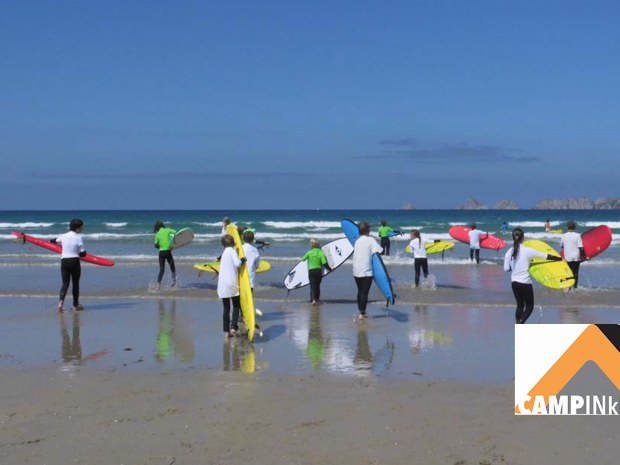 Kinder gehen während eines Surfkurs in die Wellen in der Bretagne