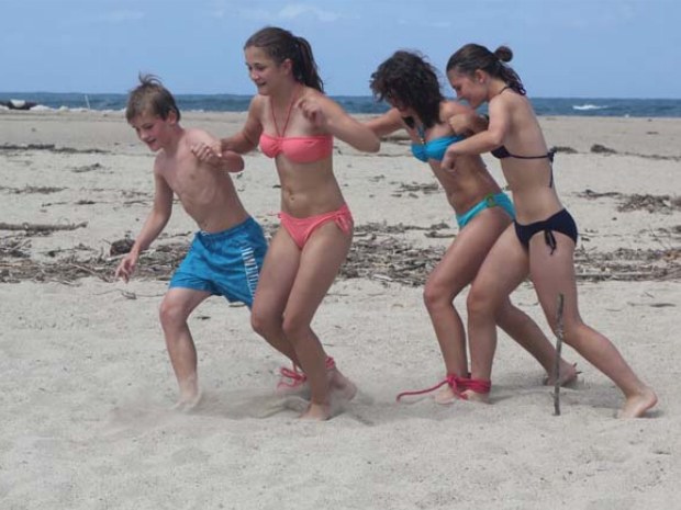 Jugendliche bei einem Strandspiel während einer Strandrallye