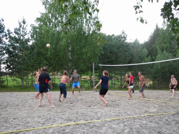 Teilnehmer spielen zusammen Beachvolleyball