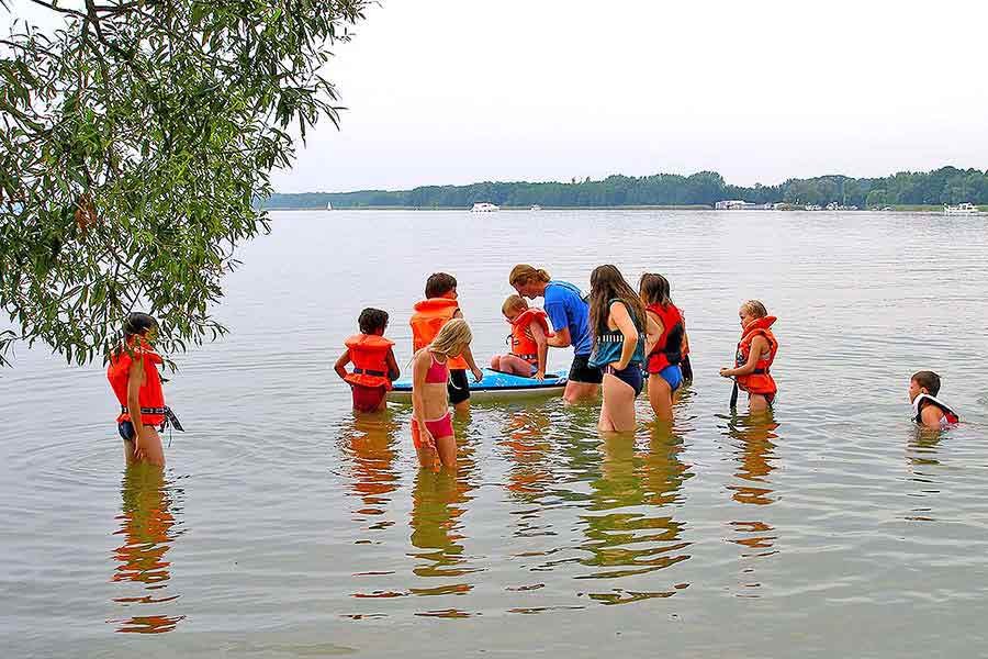 Kinder spielen im Wasser und gehen Kanu fahren